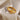 Two gold and silver rings with star designs on a soft fabric background