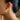 Close-up of a person wearing a gold star-shaped earring.