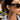 Close-up of a person wearing black sunglasses with a blurred outdoor background